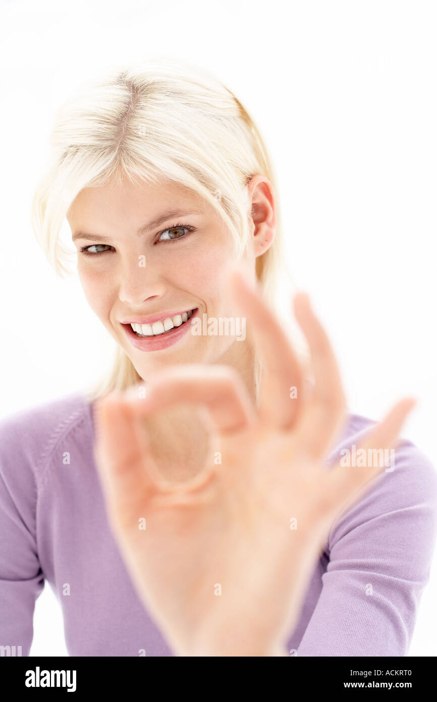 Eine junge Frau macht ein Handzeichen Stockfoto