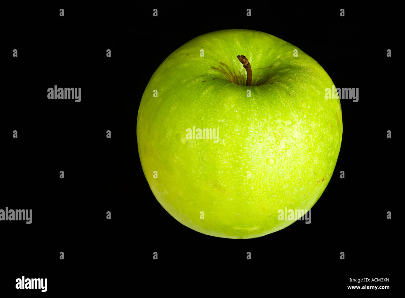 Grüner Apfel mit Wassertropfen auf schwarzem Hintergrund Stockfoto