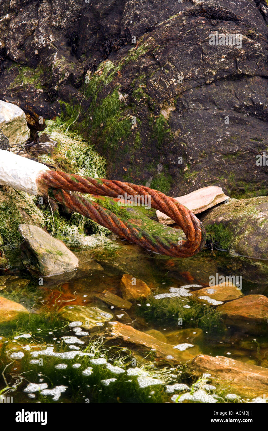 Rostige alte Kabel links auf einige Felsen. Stockfoto