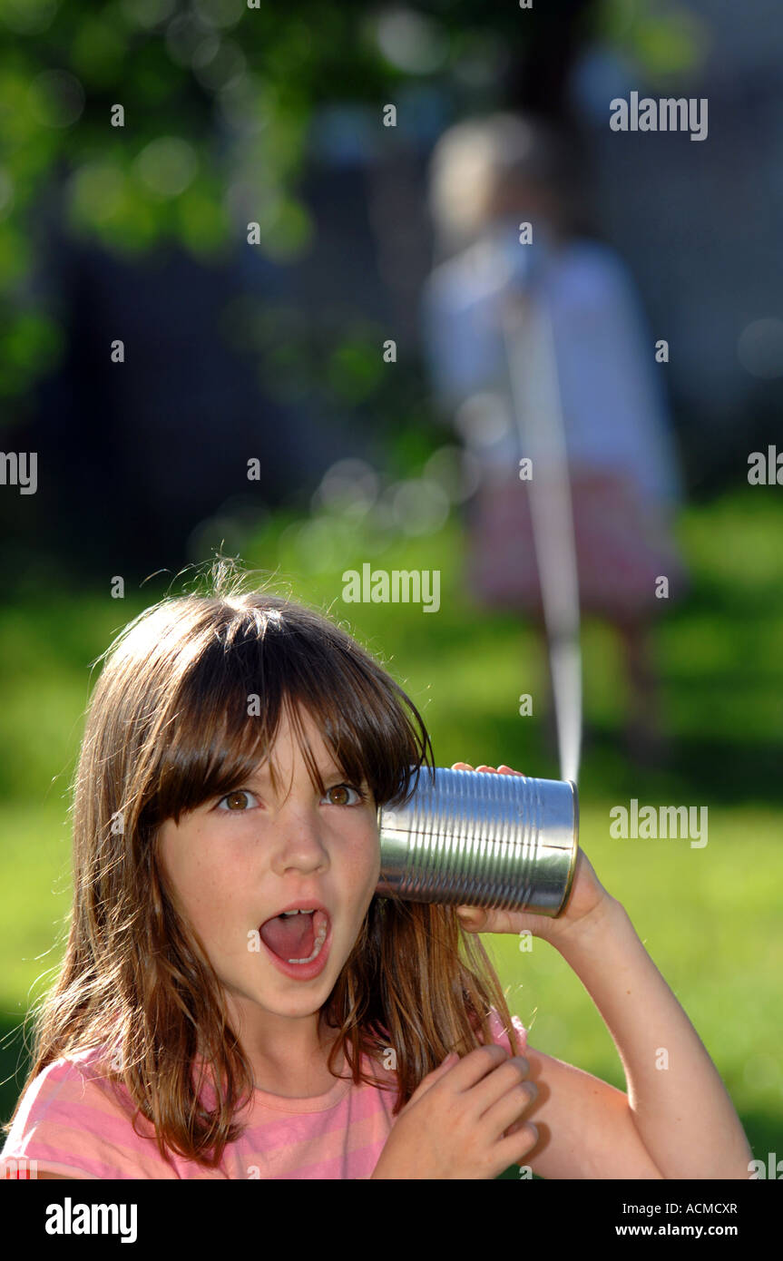Zwei Kinder verwenden eine Blechdose und Ihr String Telefon Stockfoto