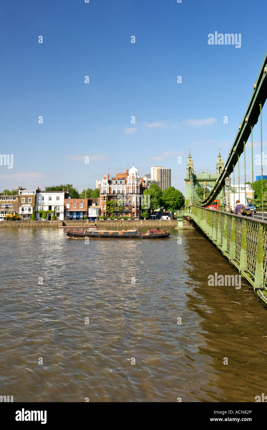 Ein Lastkahn unter Hammersmith Bridge entlang der Themse im Westen Londons. Stockfoto