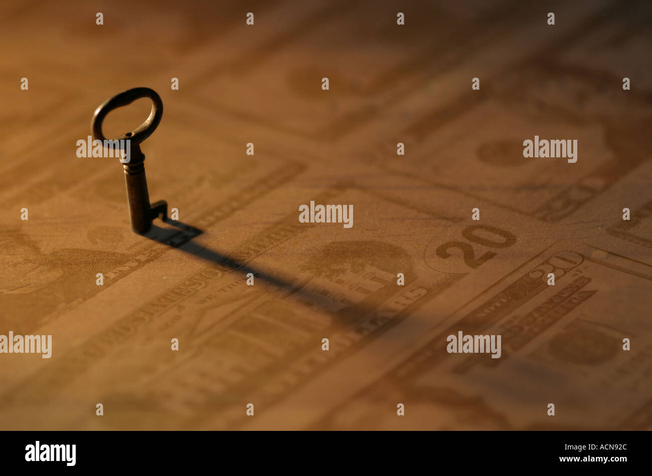 Schlüssel mit Cast Schatten Sepia Farbe auf Dollarnoten Stockfoto