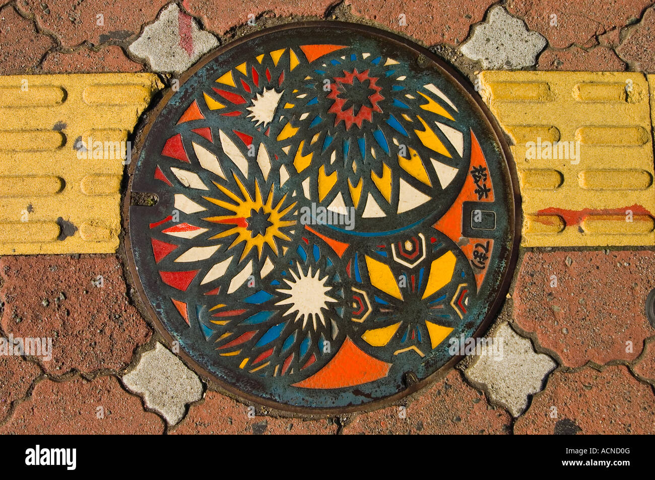 Kanaldeckel auf Stadtstraße illustrieren Matsumoto Temari Volkskunst Kugeln aus Garn in der Präfektur Nagano Matsumoto, Japan Stockfoto