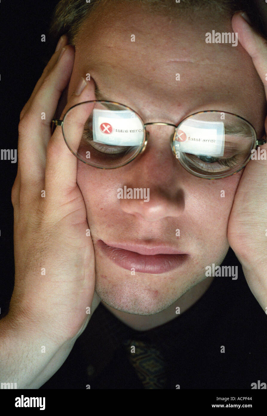 Mann am Computer mit FATAL ERROR in Brille Computer Absturz Idee Konzept reflektiert Stockfoto