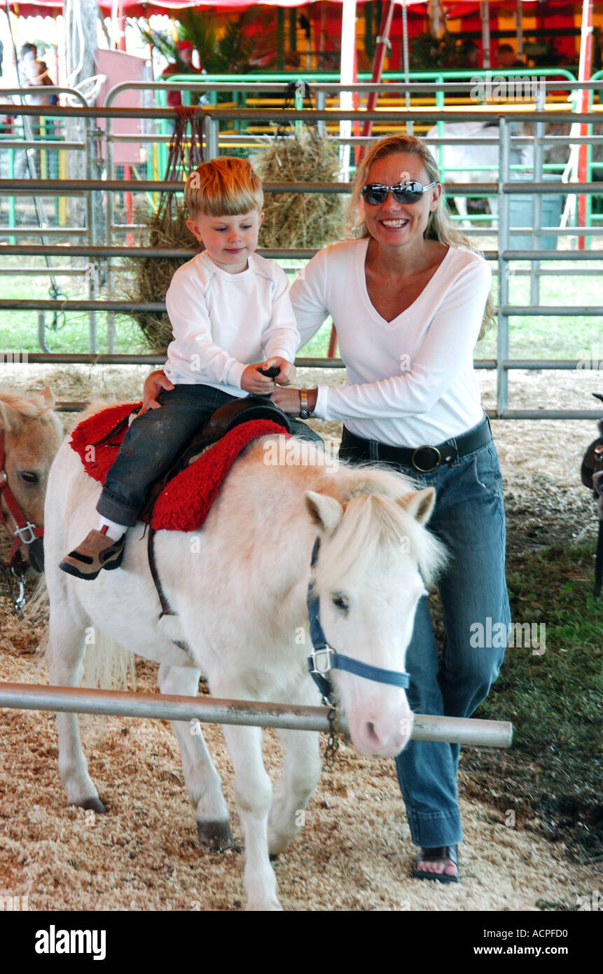 Kleiner Junge mit Mutter auf einem Pony Reiten Stockfoto