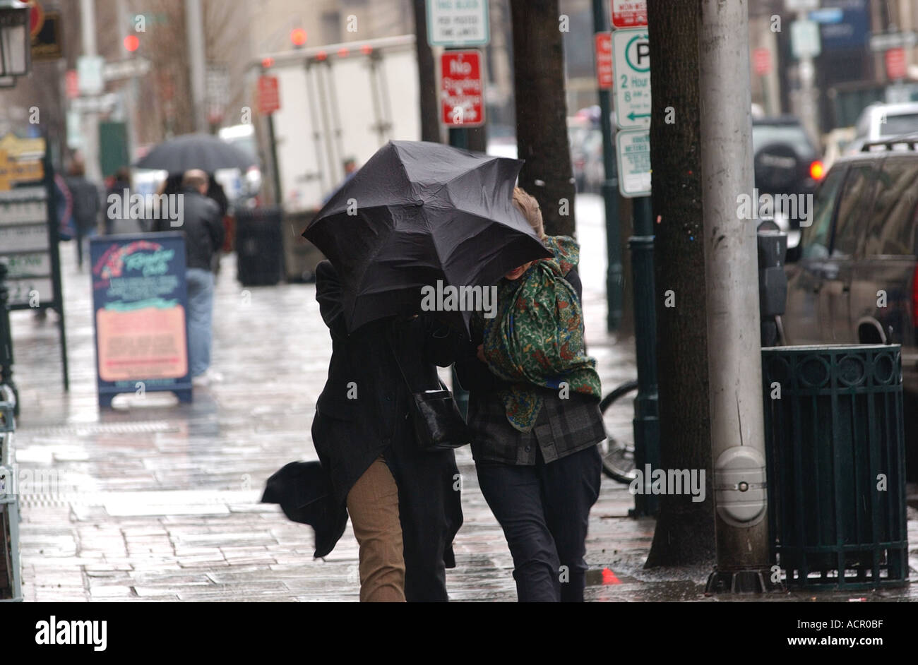 Frau erwischt im Sturm weht Regenschirm rückwärts zurück Stockfoto