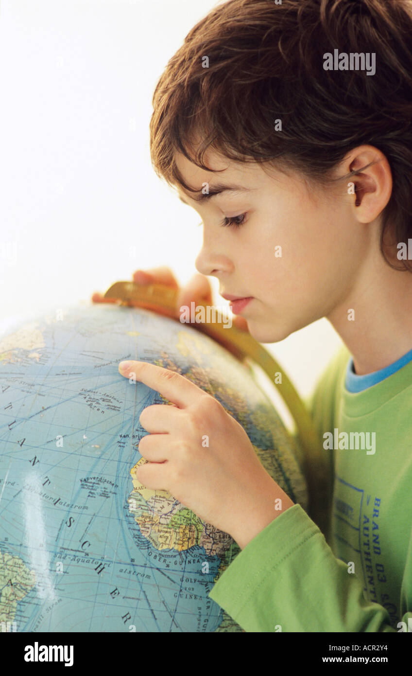 Jungen (9-10) suchen im Globe, Seitenansicht Stockfoto
