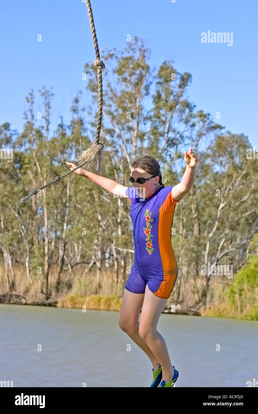 ein junges Mädchen tragen Googles hat nur ein Seil loslassen und fällt in den Fluss Stockfoto