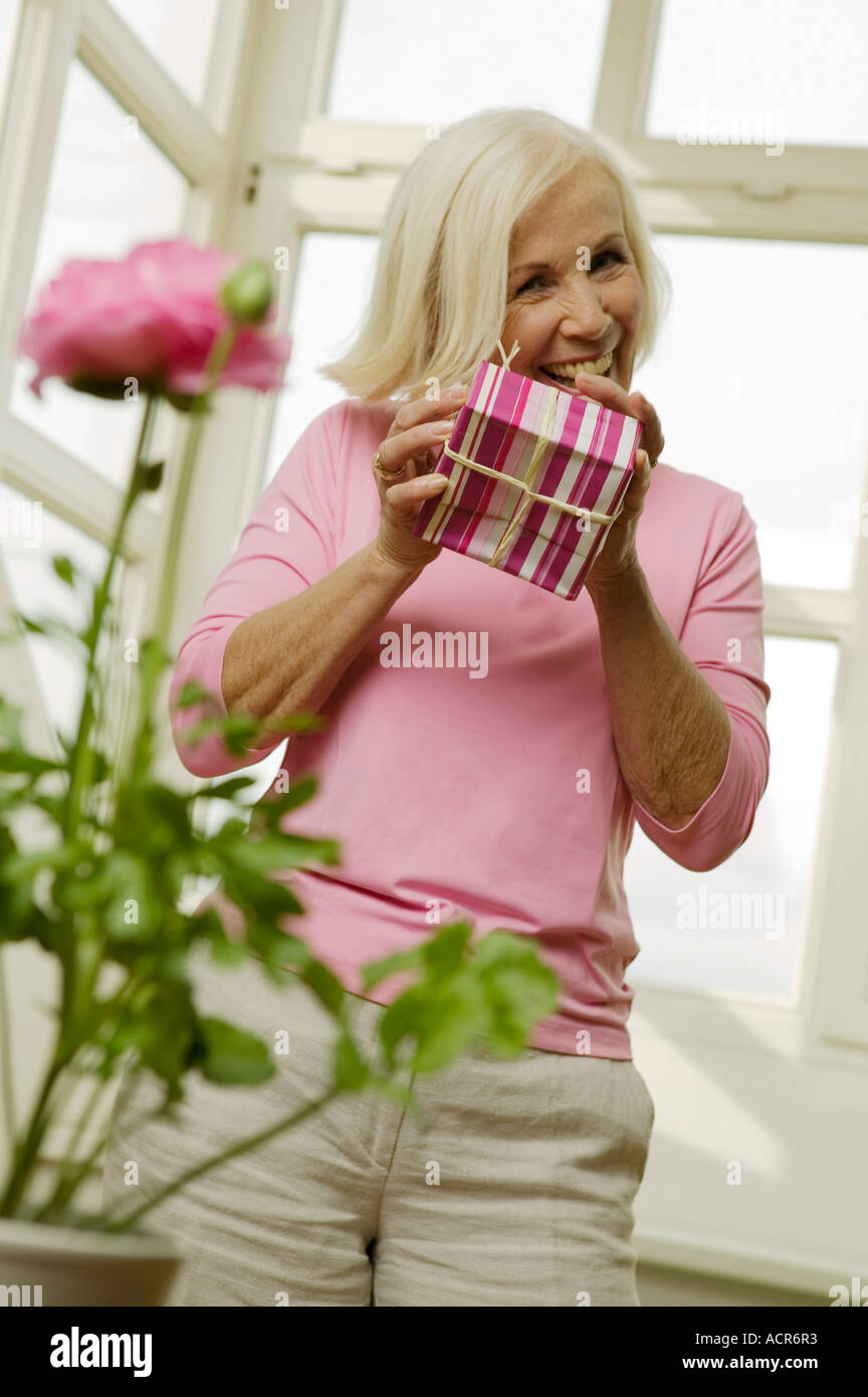 Ältere Frau hält Geschenkbox, smiling, niedrigen Winkel Ansicht Stockfoto