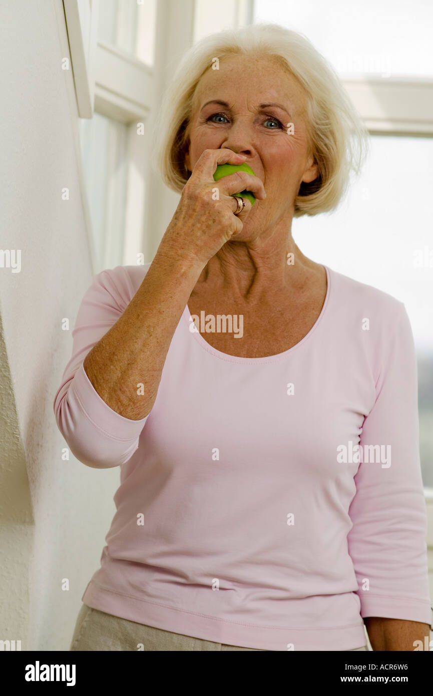 Ältere Frau essen Obst, Porträt Stockfoto