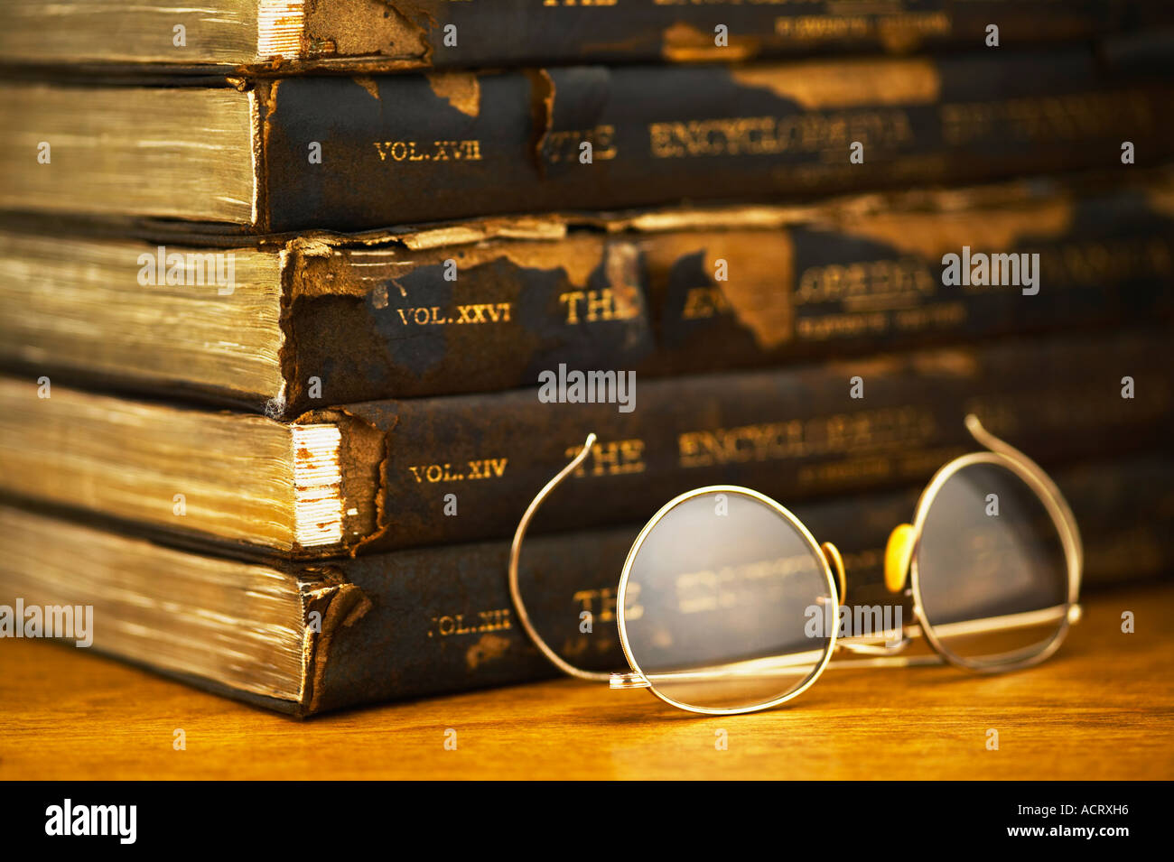 Draht-Brille neben Stapel alter Bücher Stockfoto