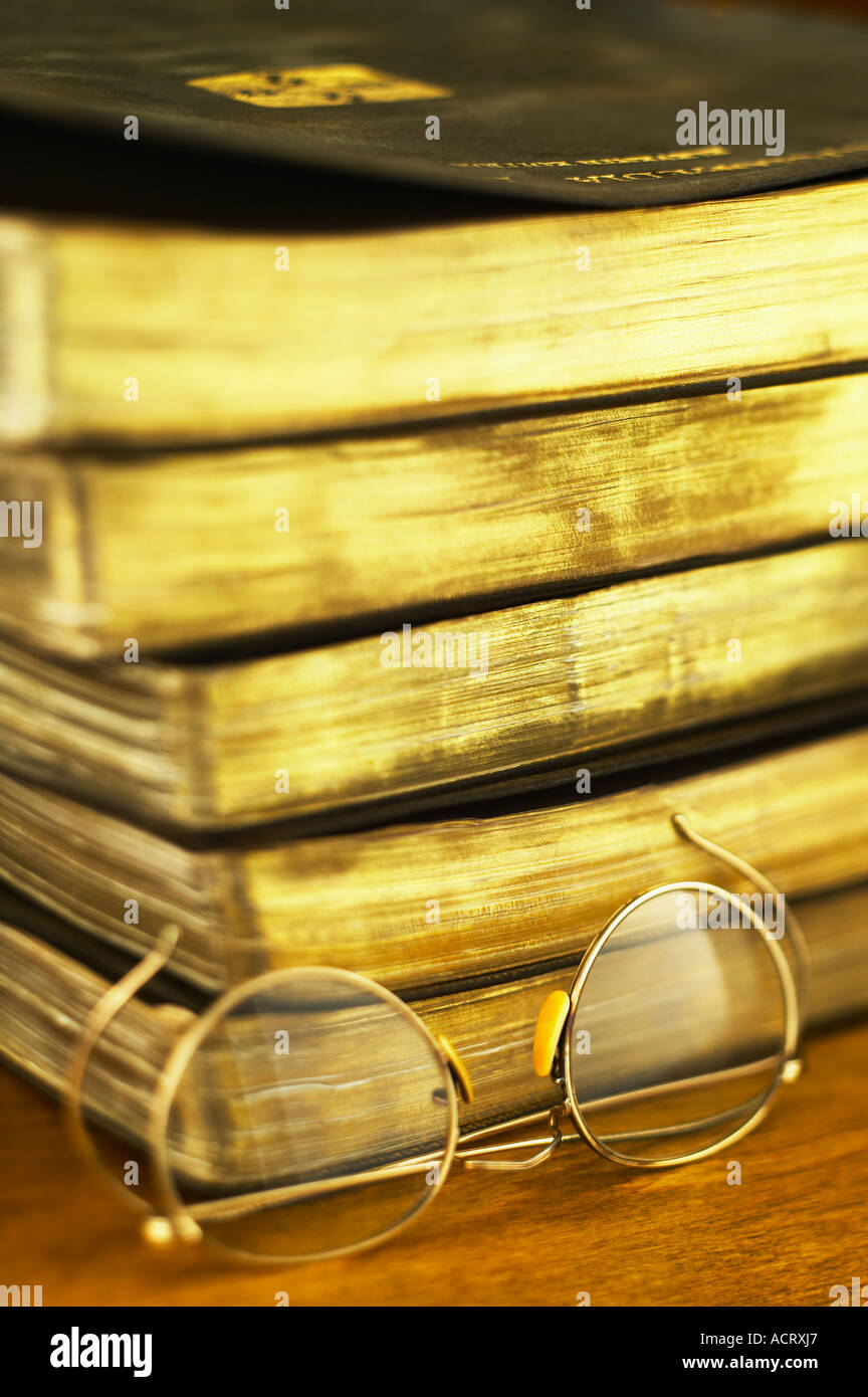 Draht-Brille neben Stapel alter Bücher Stockfoto