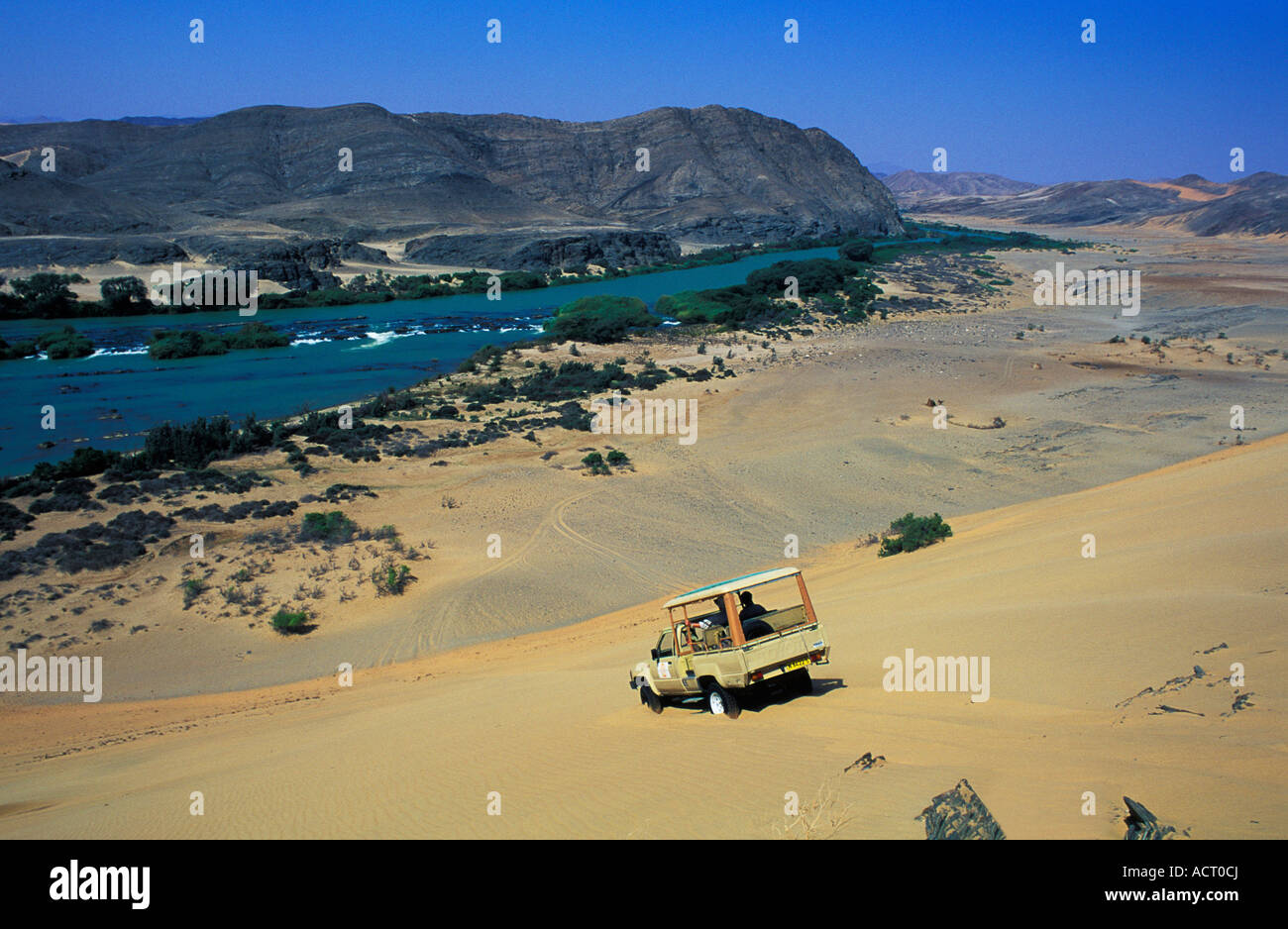Tourist-Fahrzeug auf Sanddünen über dem Kunene Fluss Skelett Küste Namibias Kunene Fluss Skelettküste Namibias Stockfoto