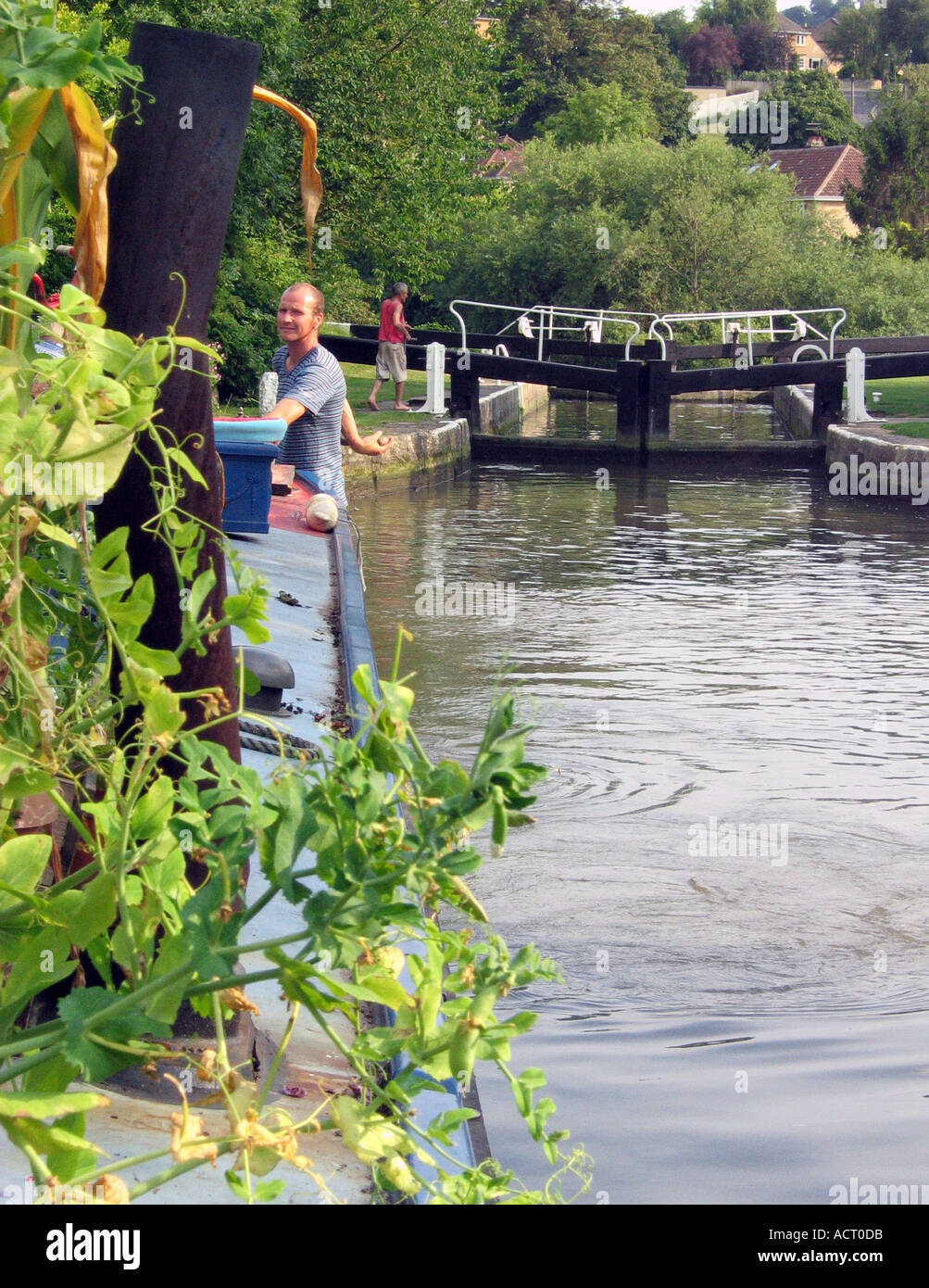 Narrowboat bedeckt in Pflanzen wegfahren von einem Schloss am Fluss Avon Stockfoto