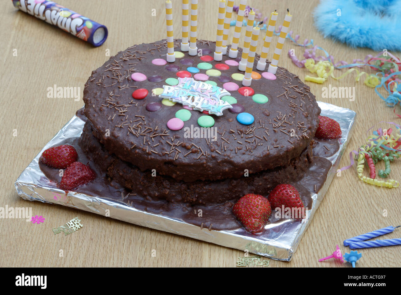 Schokoladenkuchen mit farbigen Zucker geschält, Scheiben und Kerzen Stockfoto