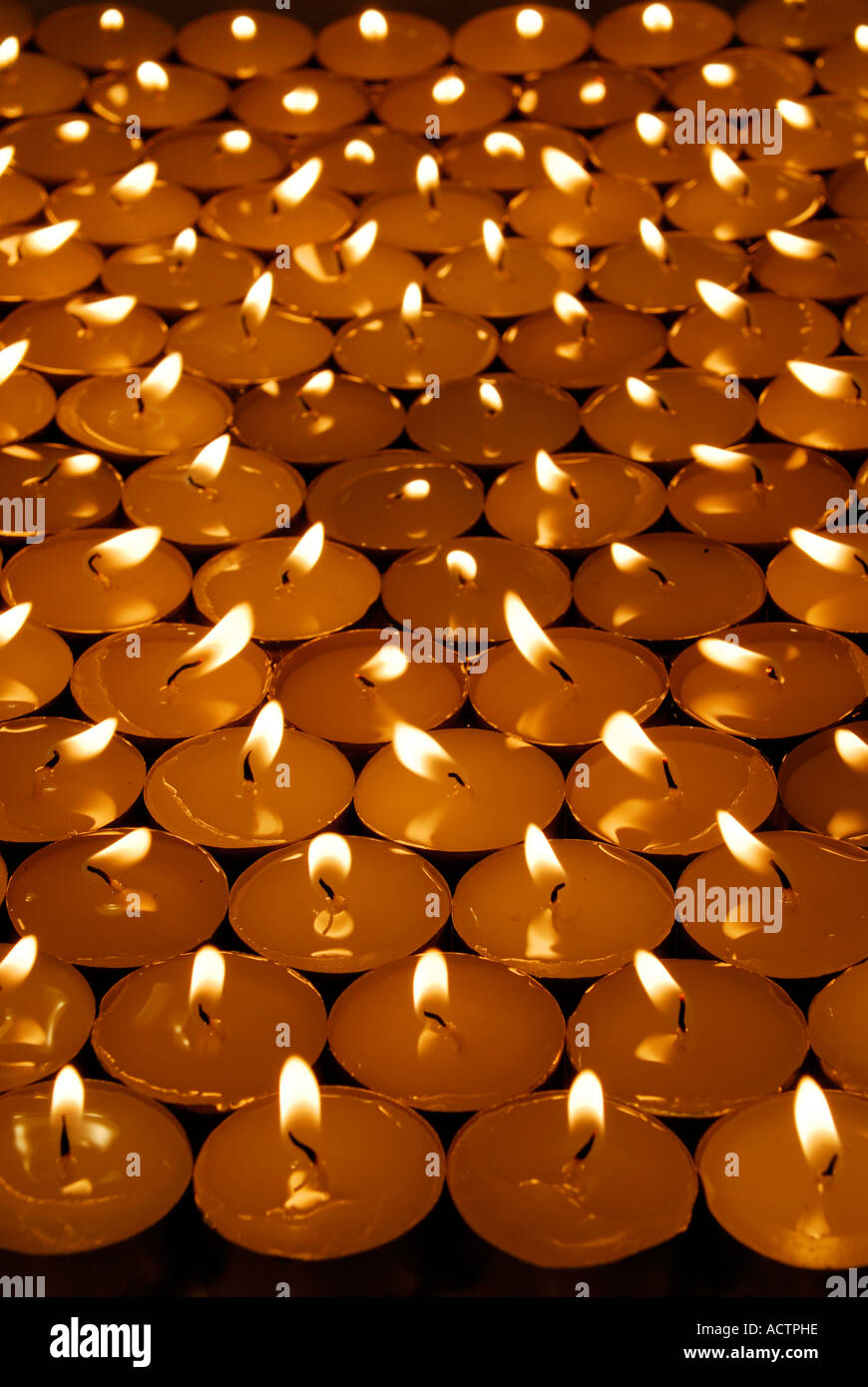 Masse der Votiv-Kerzen in einem dunklen Raum Stockfoto