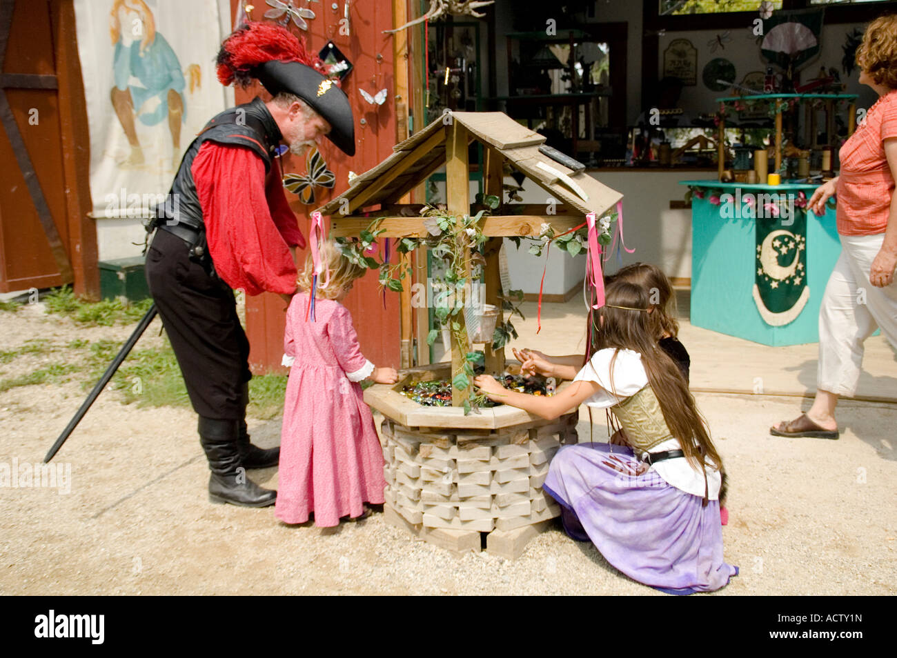 Ein Mann und drei Mädchen in Renaissance Kleid Befestigung des Brunnens Stockfoto