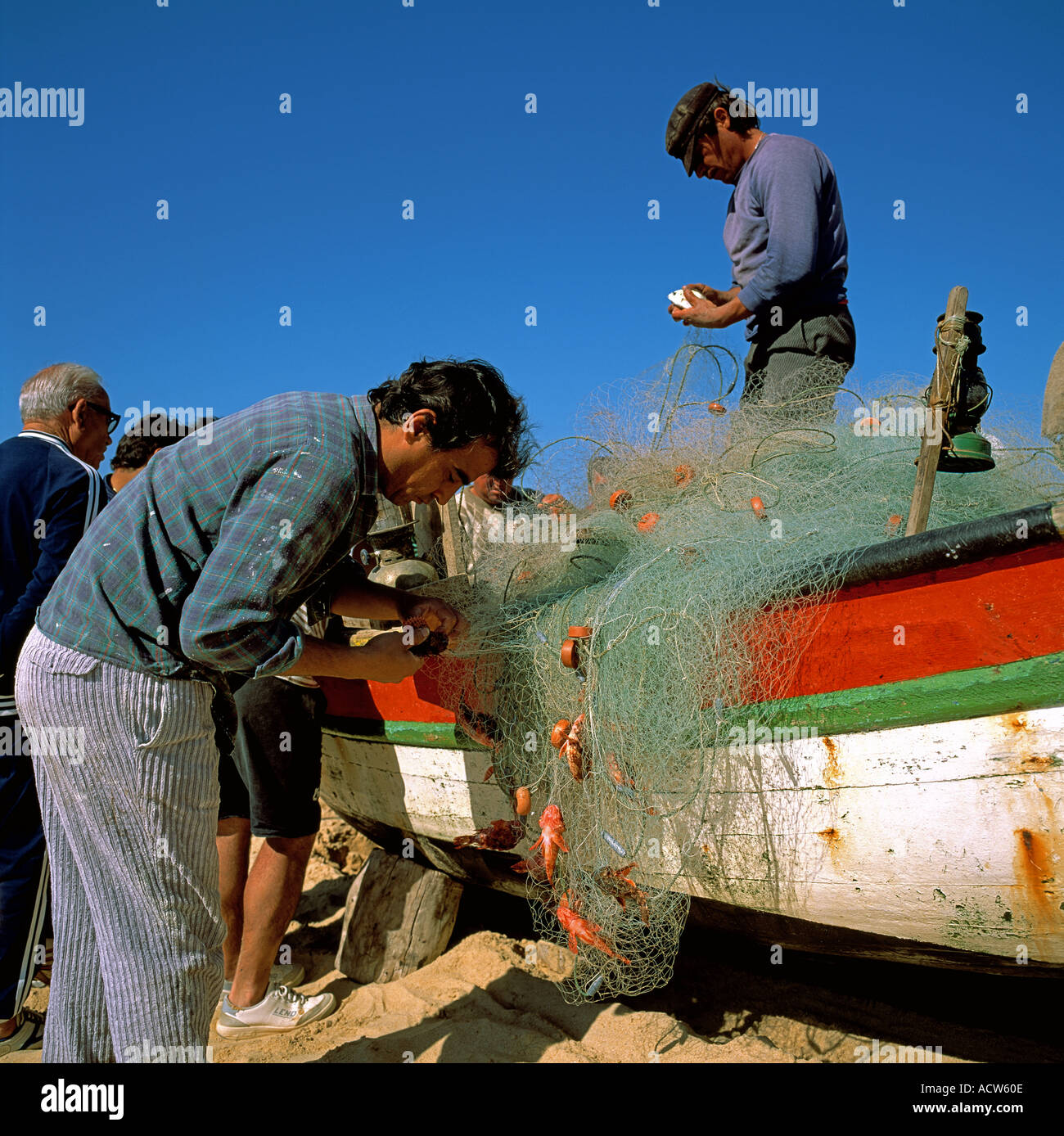 PORTUGAL ALGARVE ARMACO DE PERA FISCHER FISCHE ANGELN NET AM STRAND SAMMELN Stockfoto