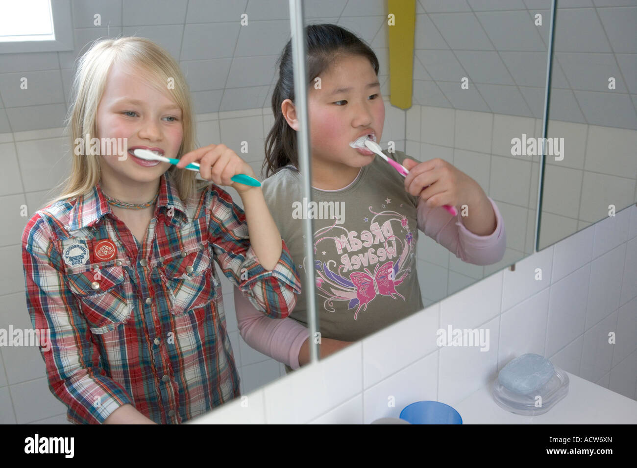 Zwei Girs sind ihre Zähne putzen. Stockfoto