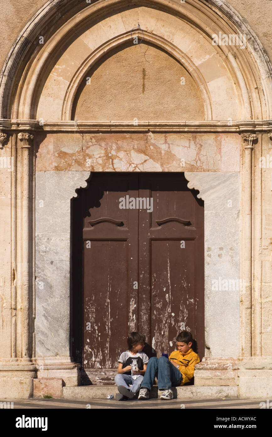 Leitartikel zu verwenden, nur kein Model release zwei italienischen Jungen sitzen im Tor der Chiesa jetzt Stadtbibliothek im April 9 Plaza in Taormina Stockfoto