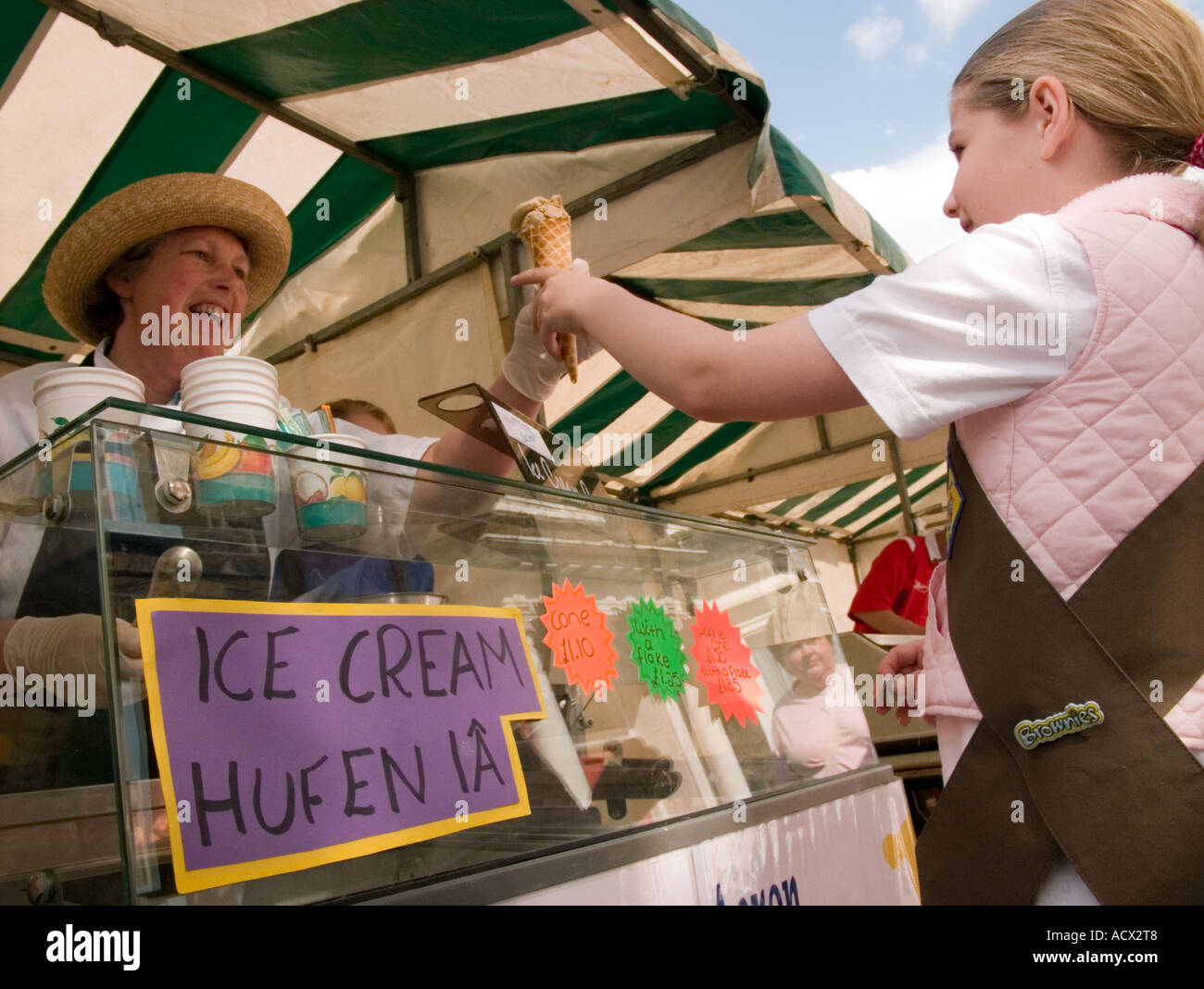 Junges Mädchen, elf Jahre alt, Kauf lokale, hausgemachte Bio Kornett Eistüte auf Aberystwyth Farmers market Stockfoto