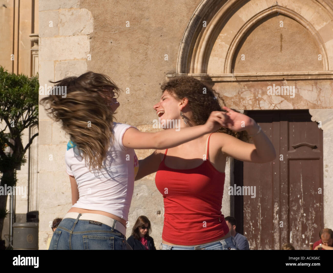 Redaktionelle Nutzung nur No model Release zwei Mädchen im Teenageralter Lachen tanzen vor der Chiesa Stadtbibliothek April 9 Plaza Taormina Stockfoto