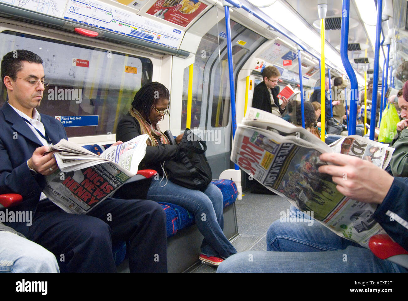 Menschen, die Zeitungen auf der Londoner U-Bahn lesen, Großbritannien Stockfoto