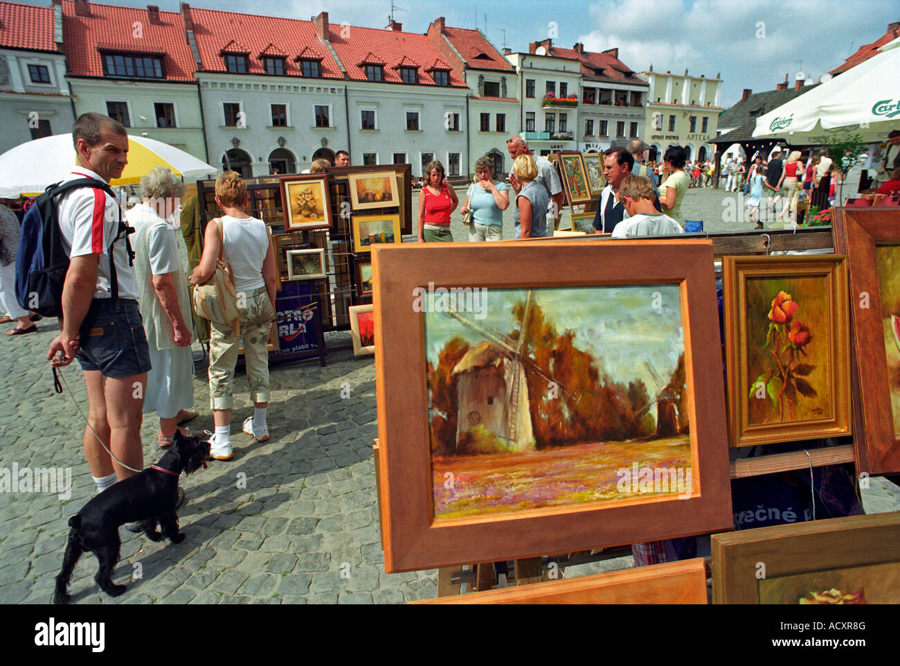 Touristen, die mit Blick auf Bilder an einem Stand auf dem alten Marktplatz in Kazimierz Dolny, Polen Stockfoto