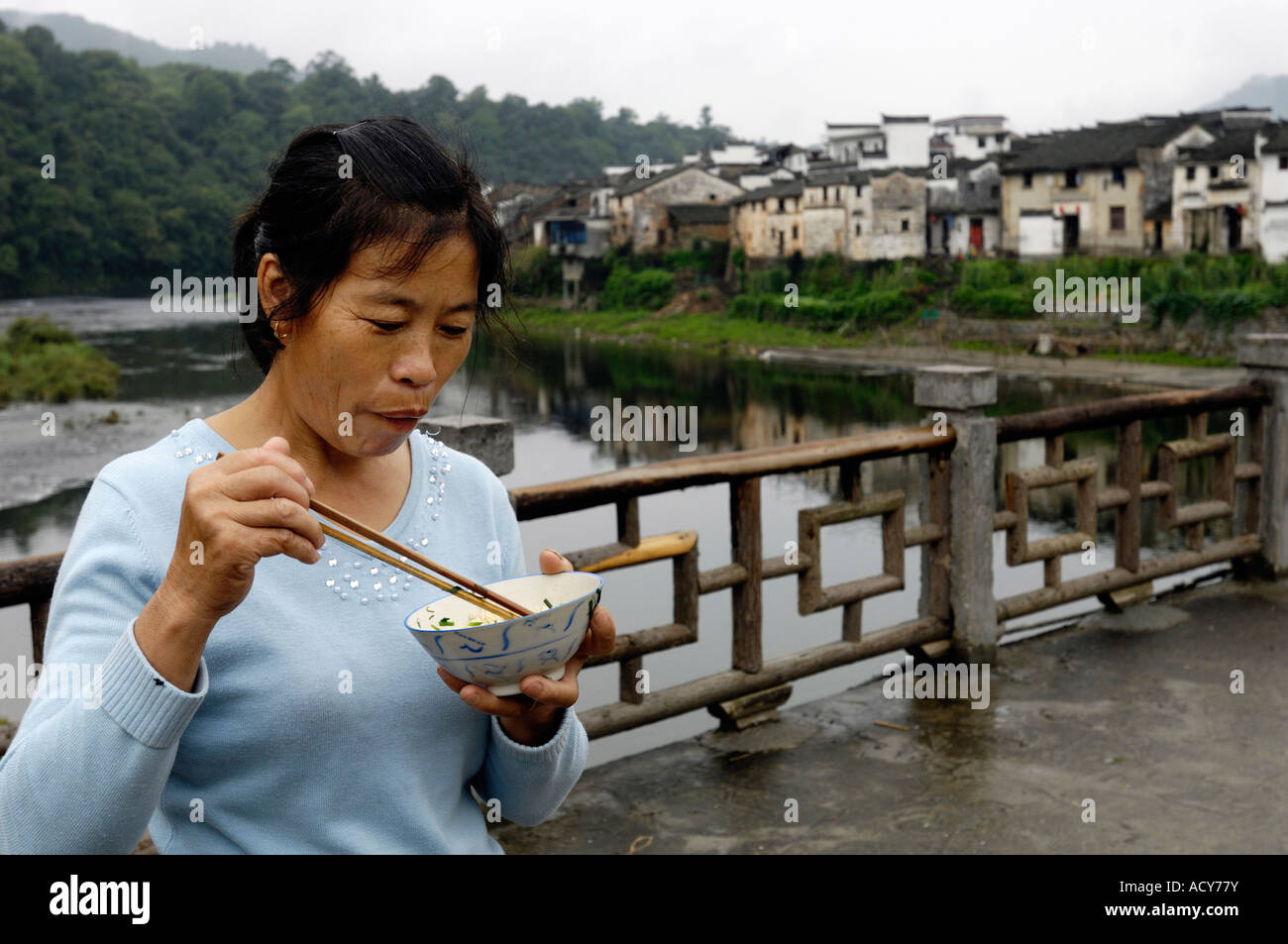 Yu Zhenli hat Mittagessen auf einer Brücke von Wangkou Dorf in Wuyuan Jiangxi China. 13. Juni 2007 Stockfoto