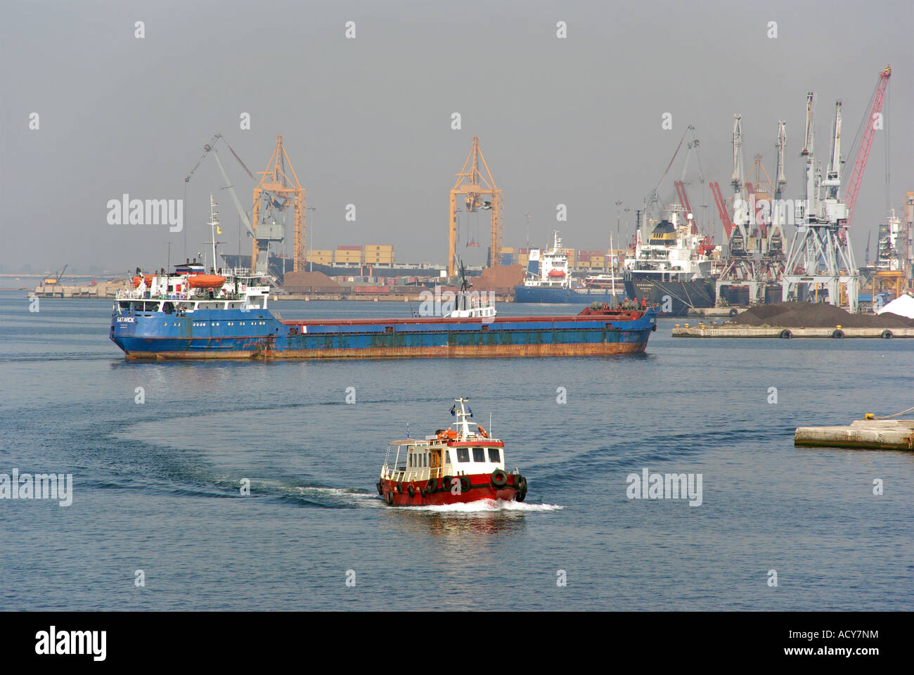 Tanker Schiff griechischen Hafen von Thessaloniki mit Dock Krane & beyond Versand mit kleinen roten Fähre in Richtung Terminal für Kreuzfahrtschiffe Griechenland bewegen Stockfoto