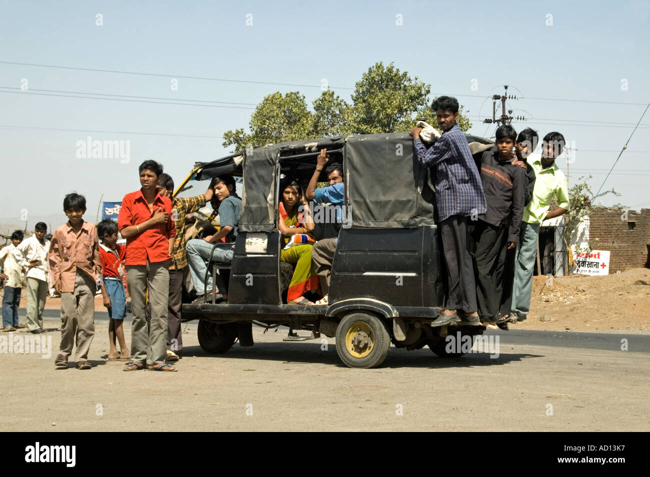 Horizontale Ansicht von einer Gruppe von indischen Kindern Pauken in eine ramponierte alte Rikscha geparkt am Straßenrand Stockfoto