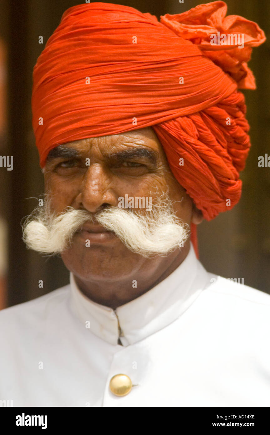 Vertikale Nahaufnahme Portrait eines traditionell gekleideten Rajasthani-Mannes mit roten Turban und riesige unverwechselbaren "Lenker" Schnurrbart Stockfoto