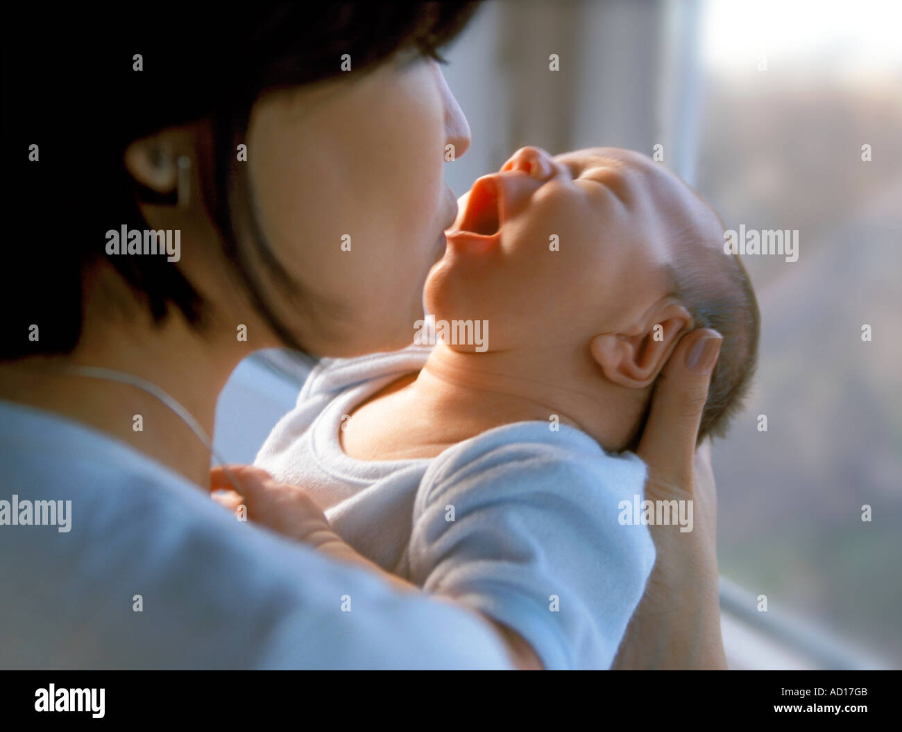 Baby Boy wird von Mutter Gähnen geküsst Stockfoto