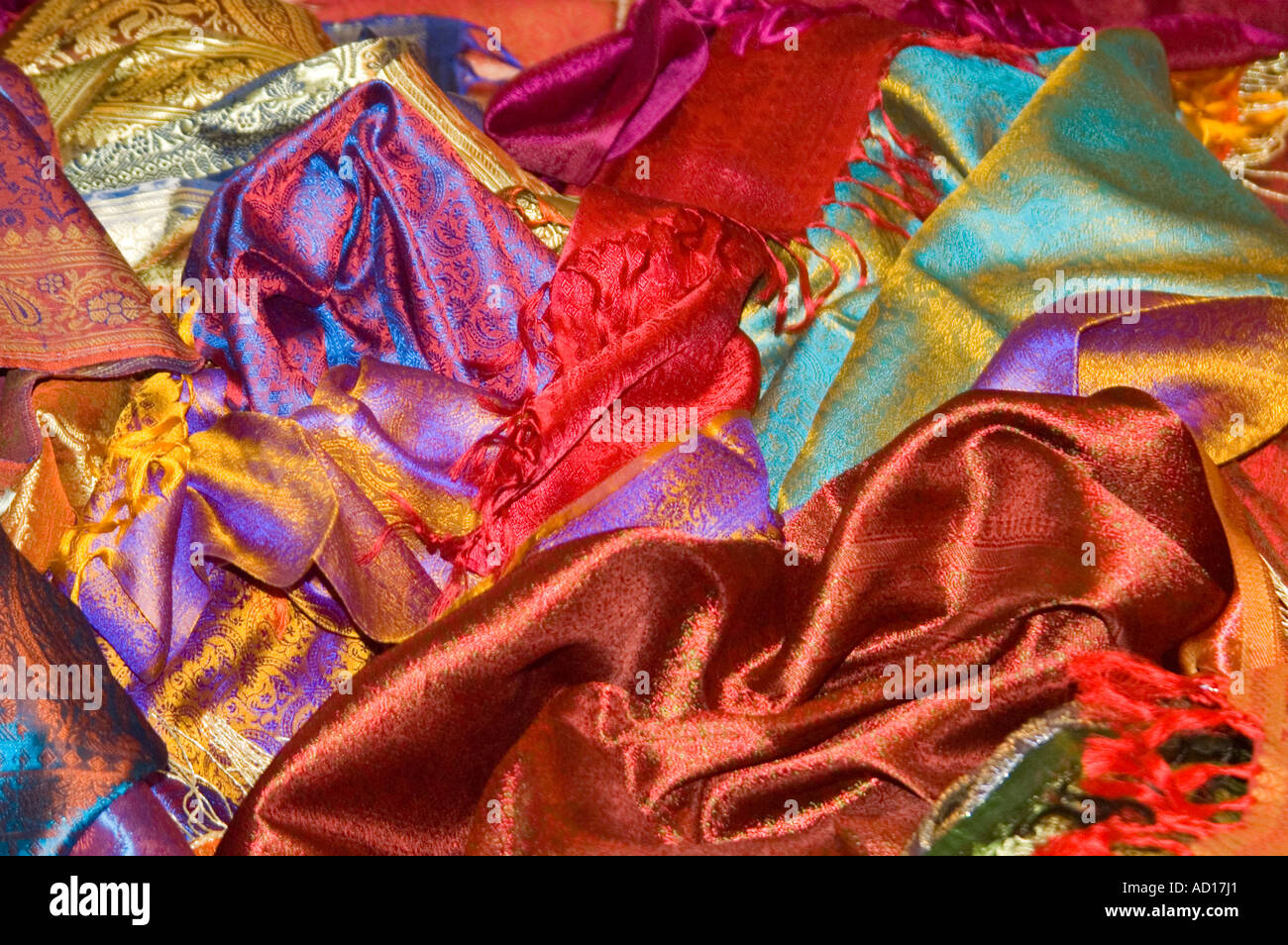 Indien Uttar Pradesh Varanasi April 2006. Horizontale Nahaufnahme von bunte Seide Saris, die verstreut auf dem Boden in einem Geschäft Stockfoto