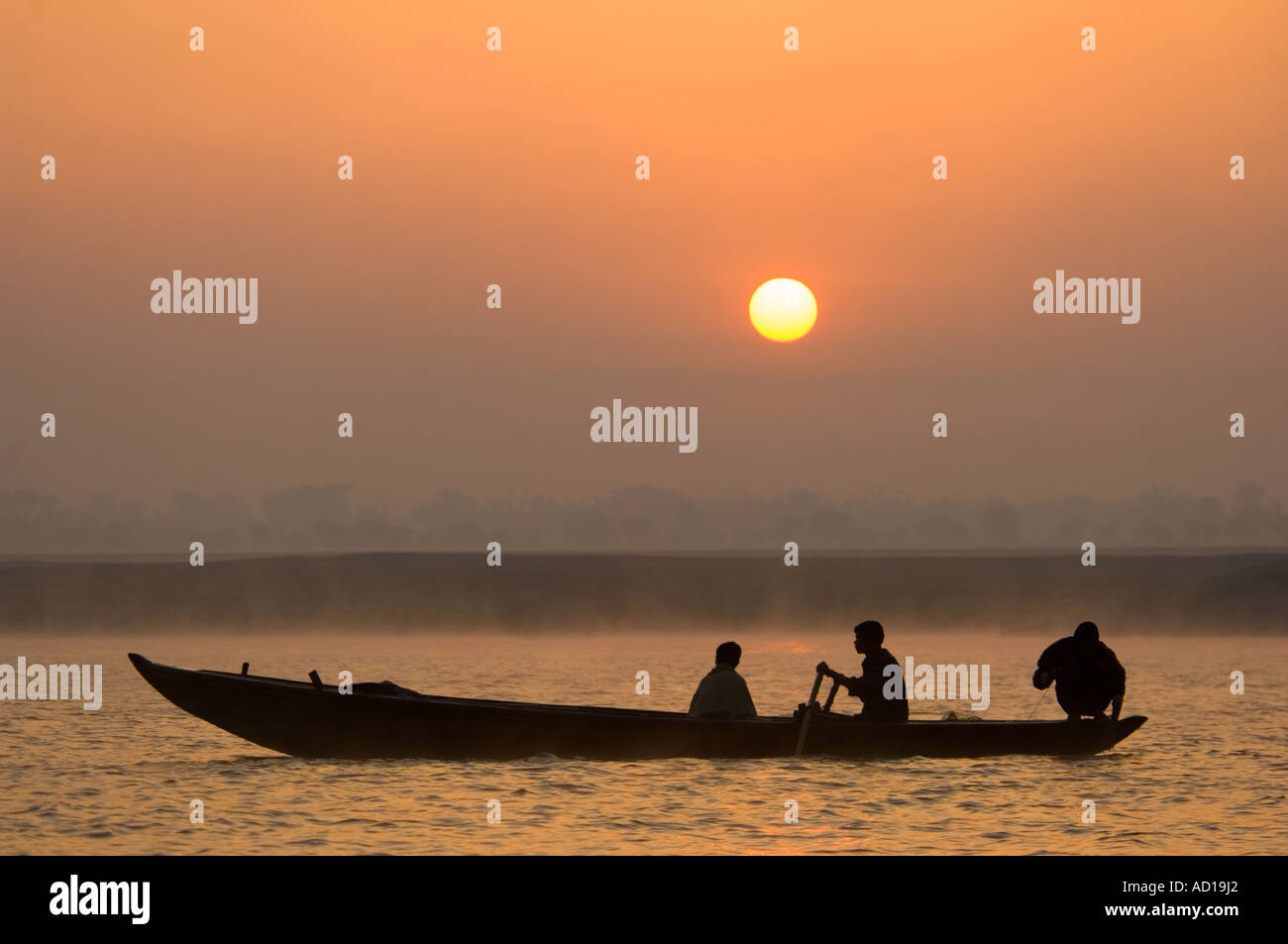Sonnenaufgang über dem Fluss Ganges (Ganga) mit einheimischen Männer Angeln und Silhouette gegen die aufgehende Sonne. Stockfoto