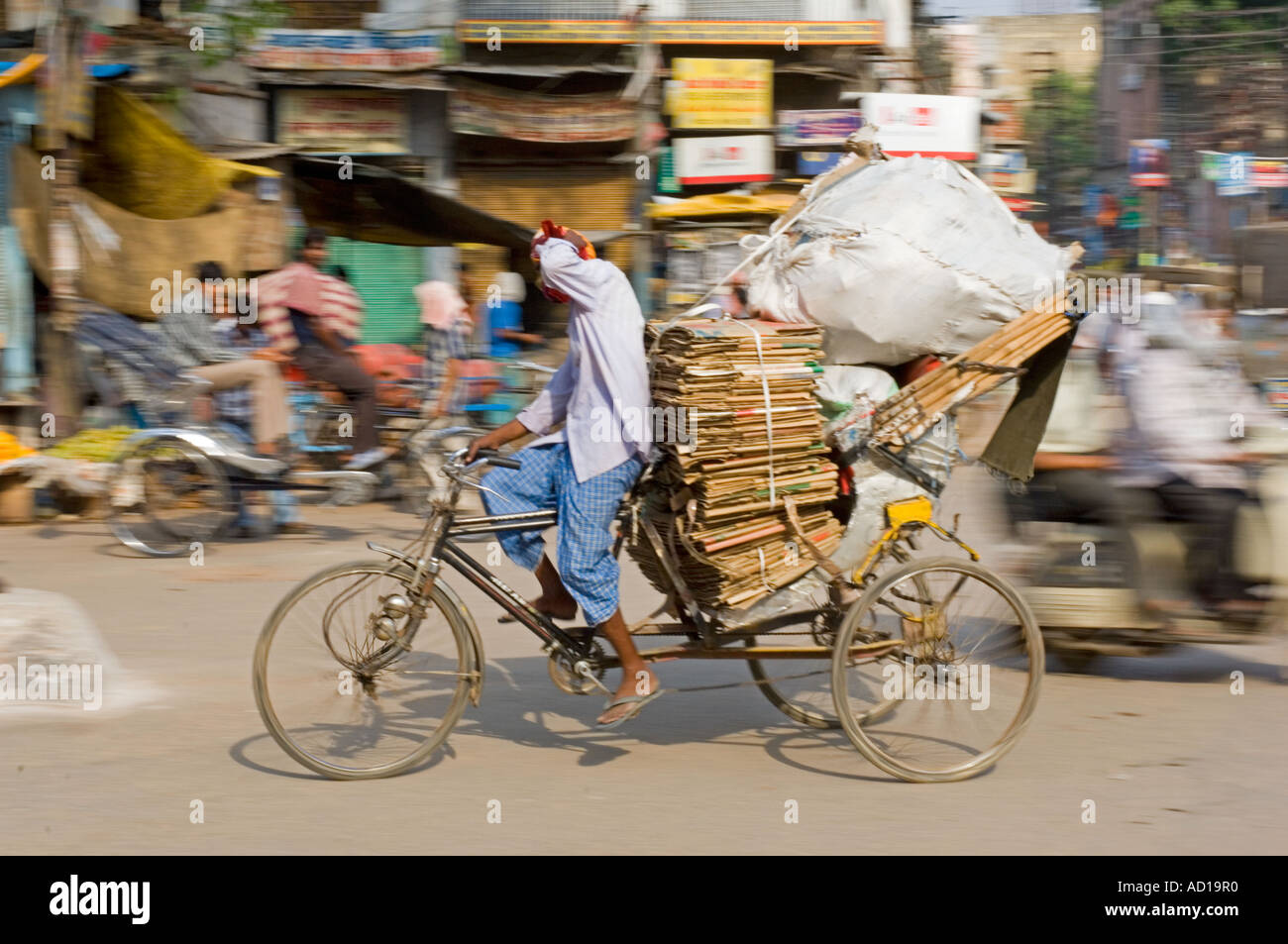 Eine überladene Fahrradrikscha in Varanasi.  Langsame Verschlusszeit und schwenken für Bewegung verwischen. Stockfoto