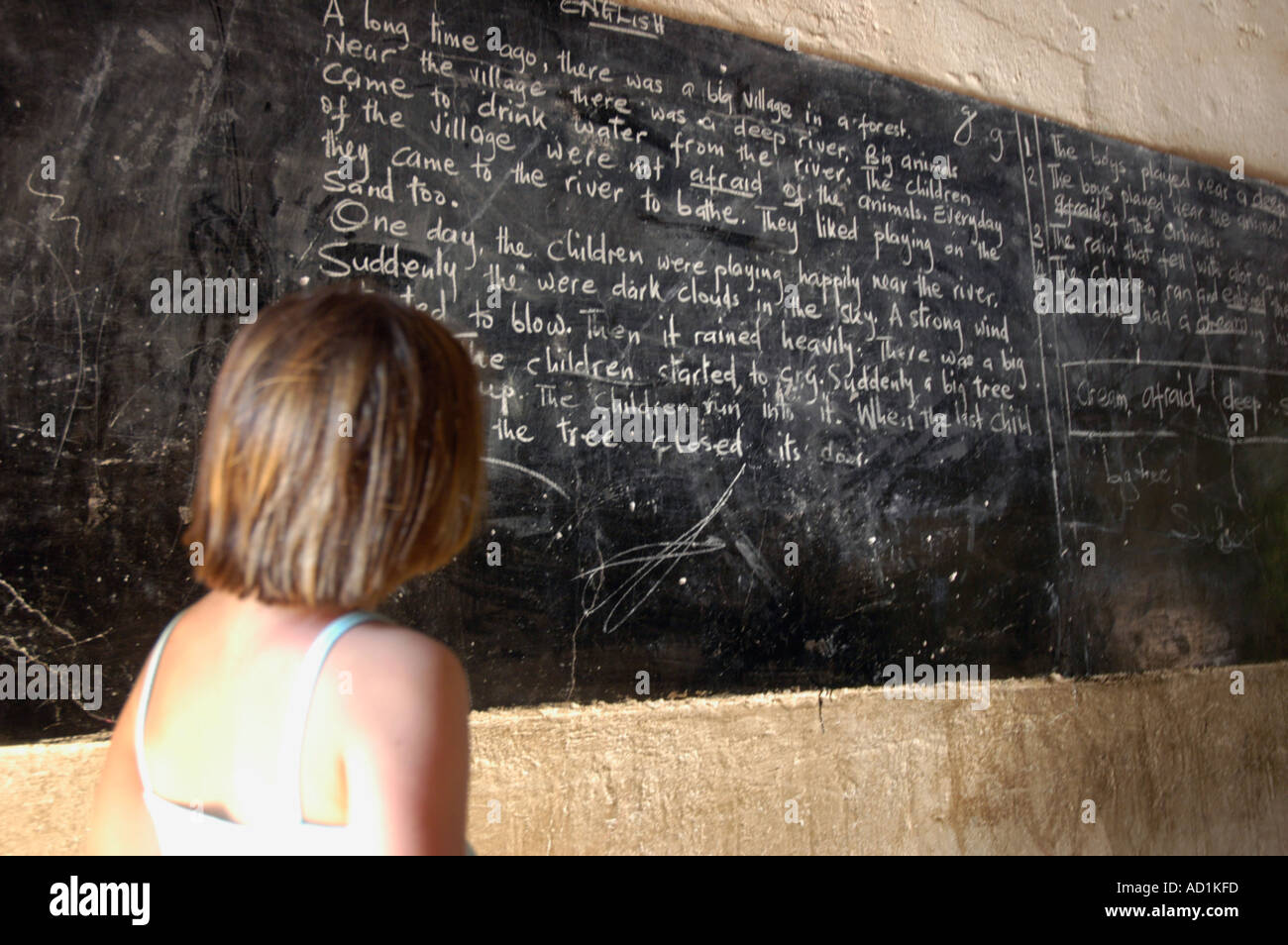 weißen südafrikanischen Mädchen Blick auf eine Schultafel in Malawi Stockfoto