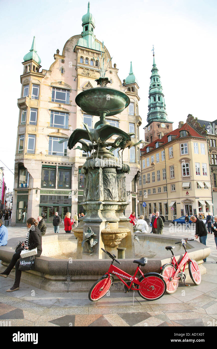 Freie Stadtfahrräder geparkt durch einen Brunnen in Kopenhagen Stockfoto