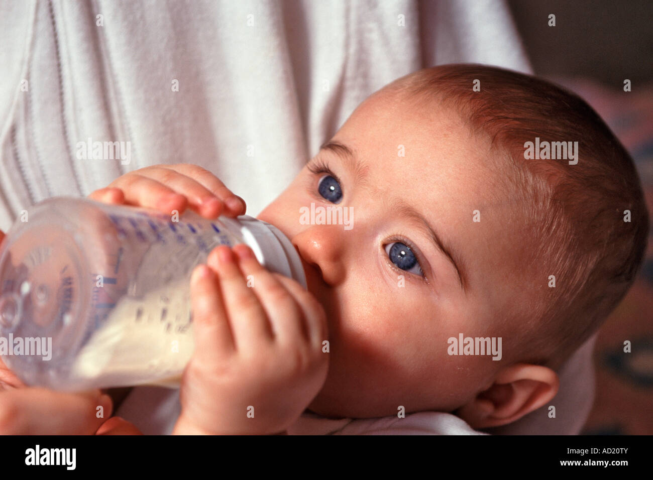Ein kleines Mädchen speist sich aus einer Babyflasche. Stockfoto