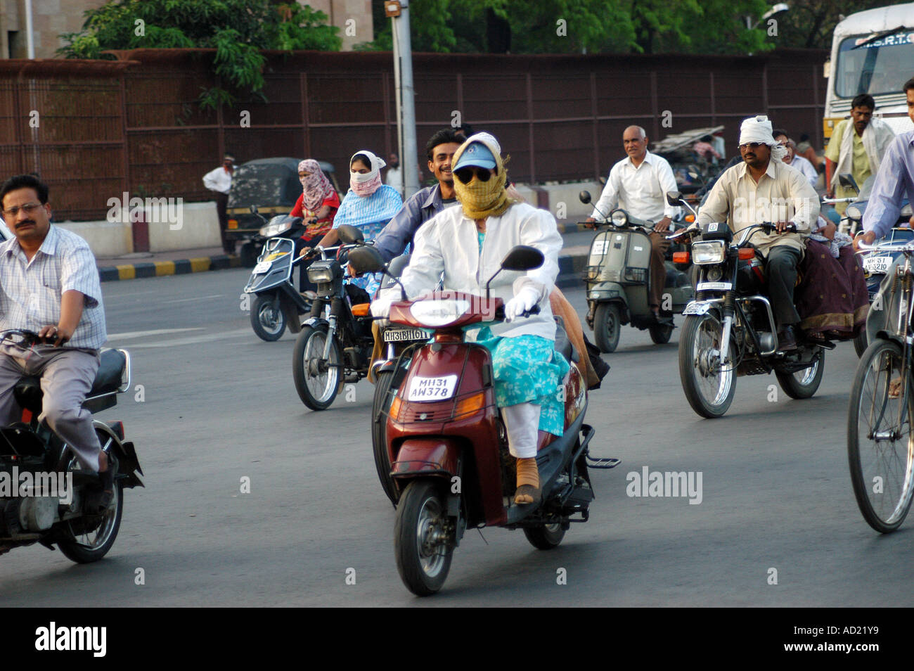 ASB73141 indische Frau fahren ein Motorrad Roller Zweirad bedeckt ihr Gesicht mit Schal um Hitze zu vermeiden Stockfoto