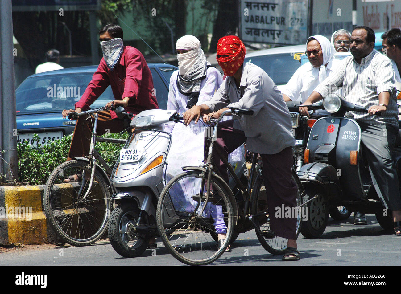 Zwei Radfahrer bedecken ihre Gesichter mit Schals für Sicherheit und Schutz bei sommerlicher Hitze in Nagpur Maharashtra Indien Stockfoto