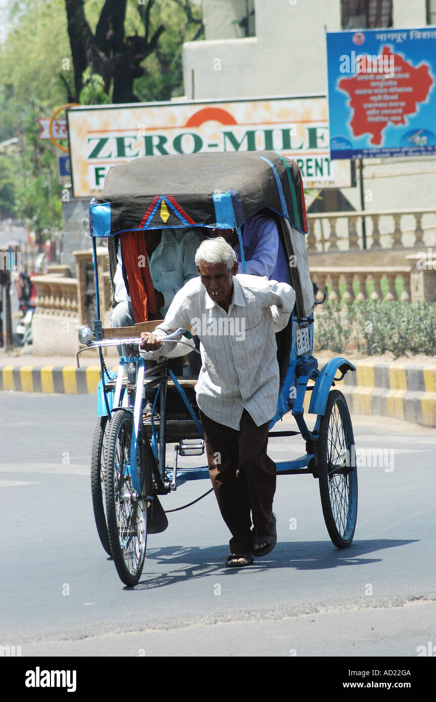 ASB73155 Einem alten Zyklus Rickshaw Abzieher Passagiere in Nagpur, Maharashtra, Indien Stockfoto