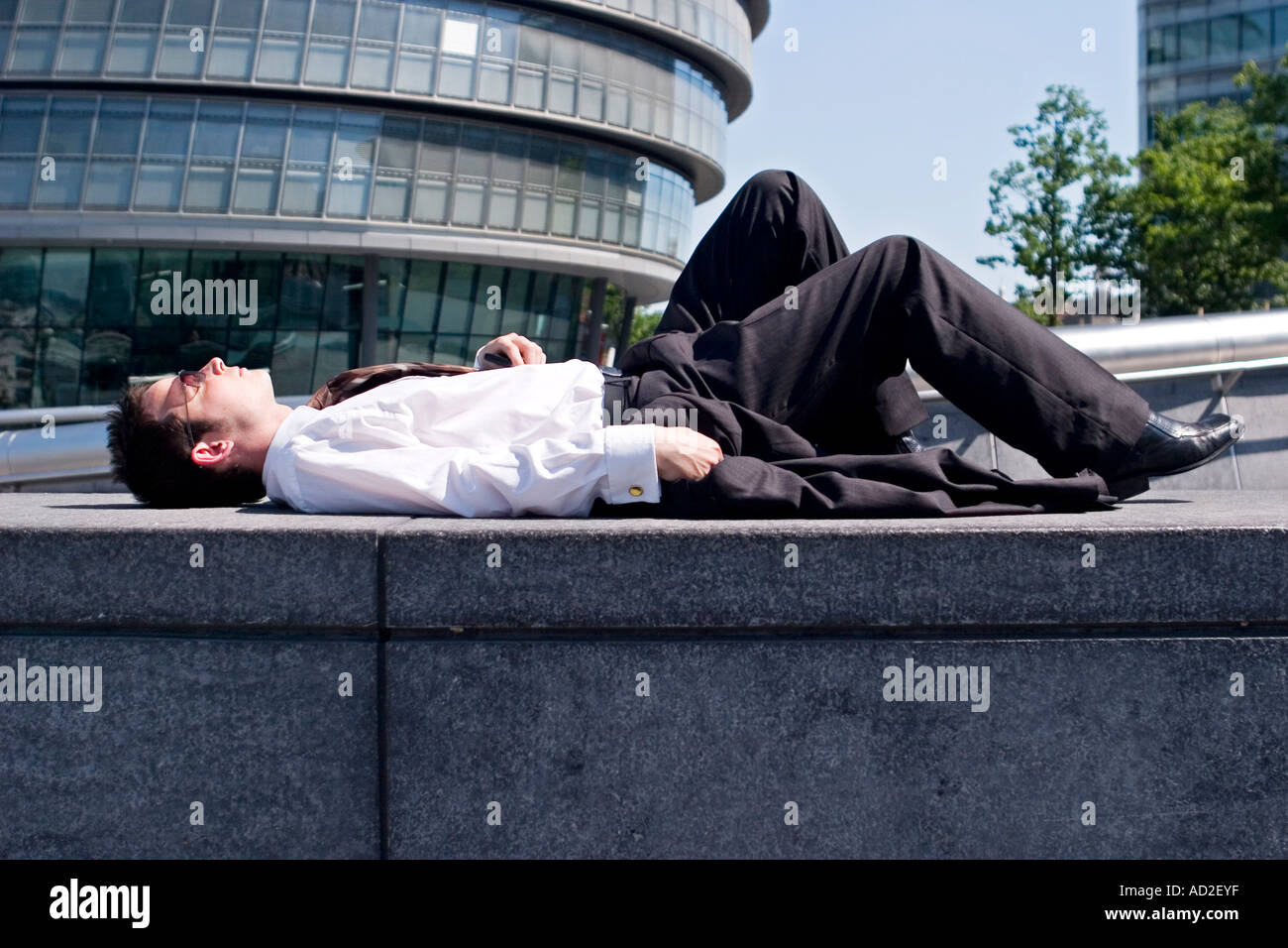 Junger Geschäftsmann entspannt sich in der Entwicklung mehr London Ort in der Nähe von London City Hall Stockfoto