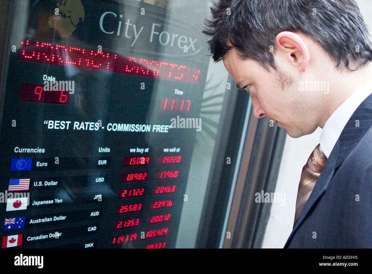 Junger Geschäftsmann befasst sich mit Devisen Preise Board in der City of London Stockfoto