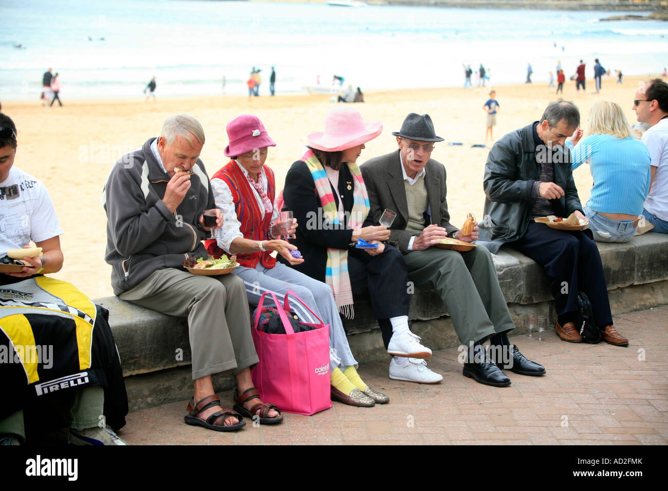 Eine Gruppe älterer Menschen Essen zum mitnehmen in der Nähe von Strand von Manly Wein und Essen festival Stockfoto