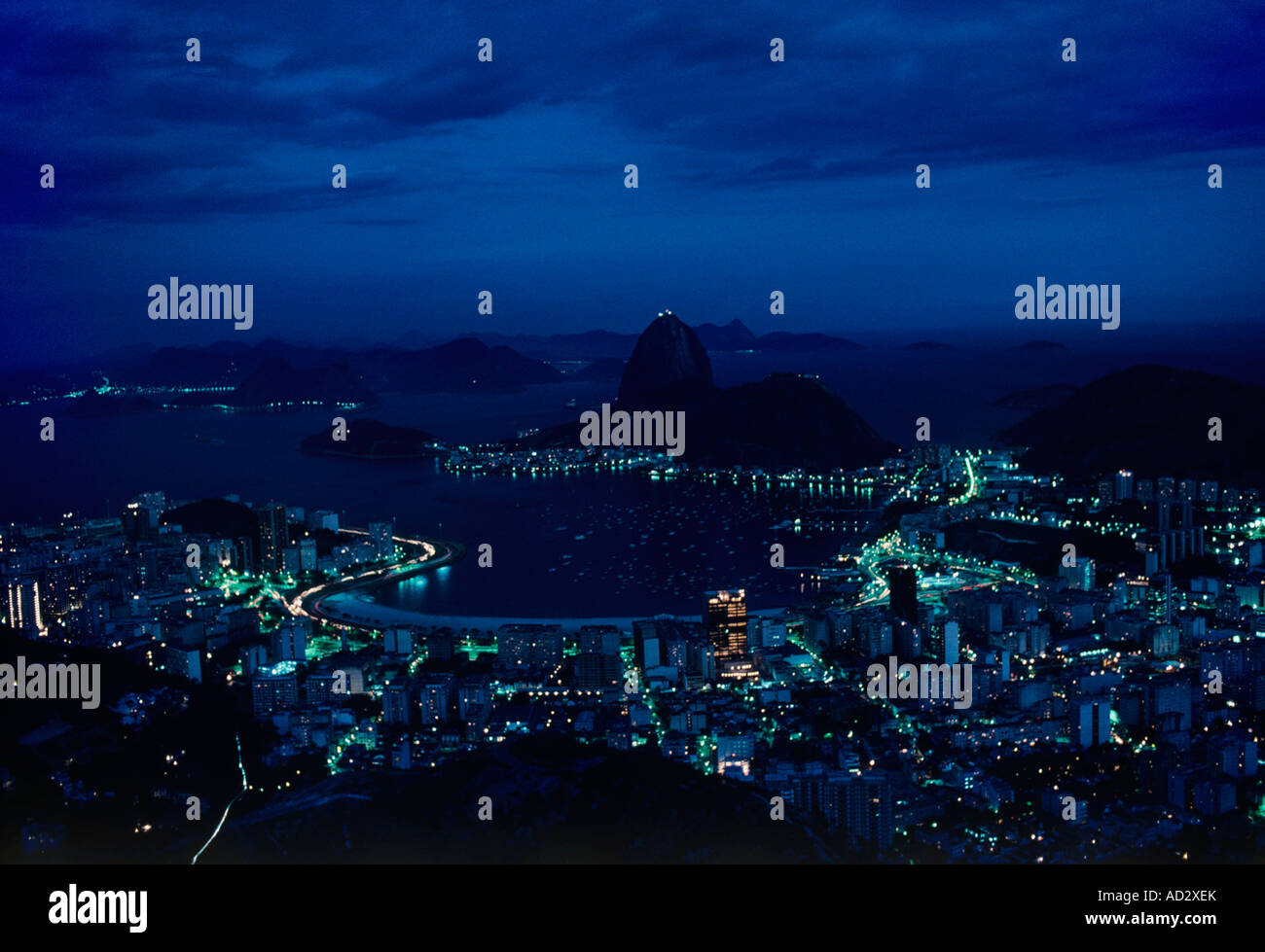 Rio De Janeiro in der Dämmerung wie die Lichter rund um den Hafen und die Bucht umgebenden Zuckerhut weitergehen. Stockfoto
