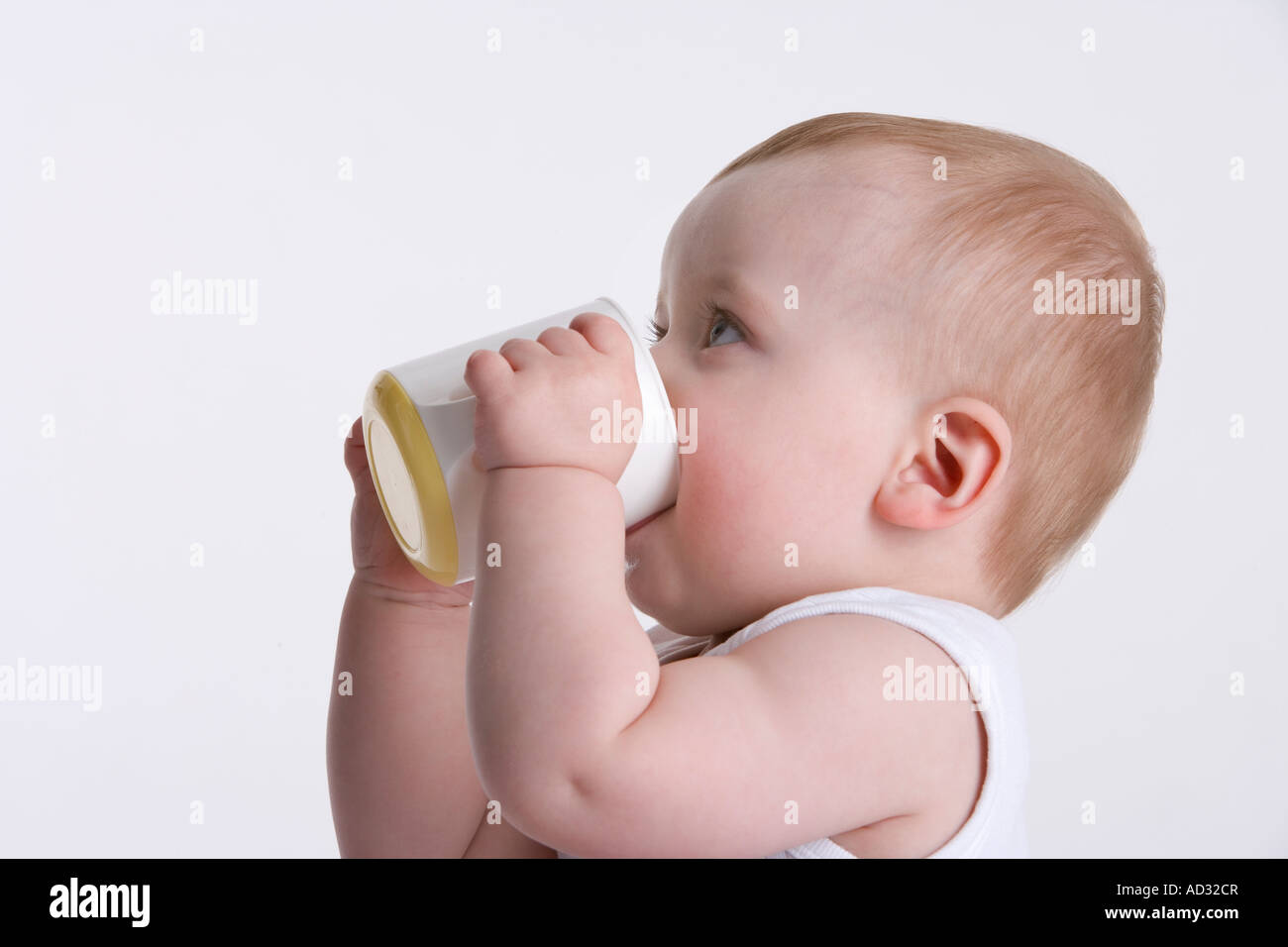 Baby Boy trinken aus einer Baby-Tasse selbst Stockfoto