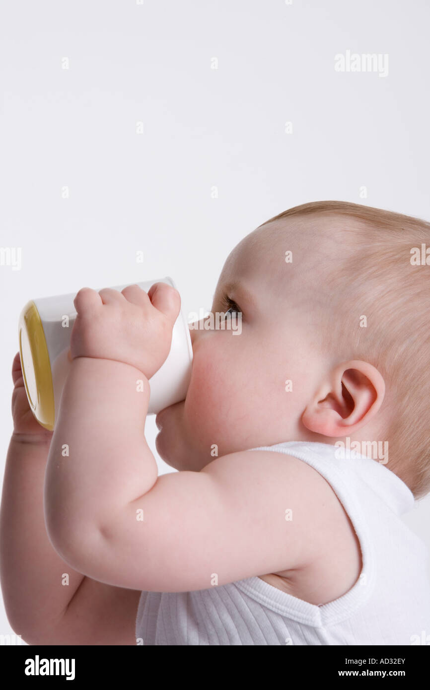 Baby Boy trinken aus einer Baby-Tasse selbst Stockfoto