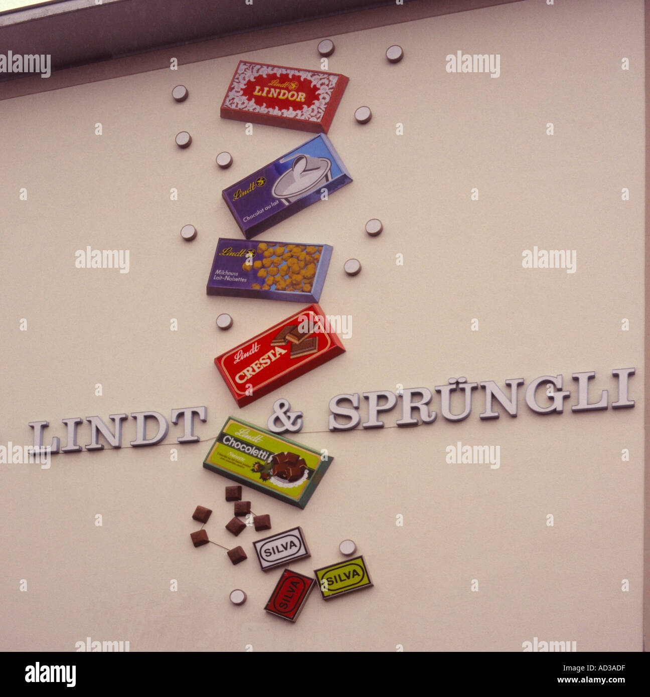 & Sprüngli Lindt Schokolade Fabrik Zeichen groß auf Wand mit ihren Titel und Riese Modell Bars Schokolade Zürich Schweiz Stockfoto
