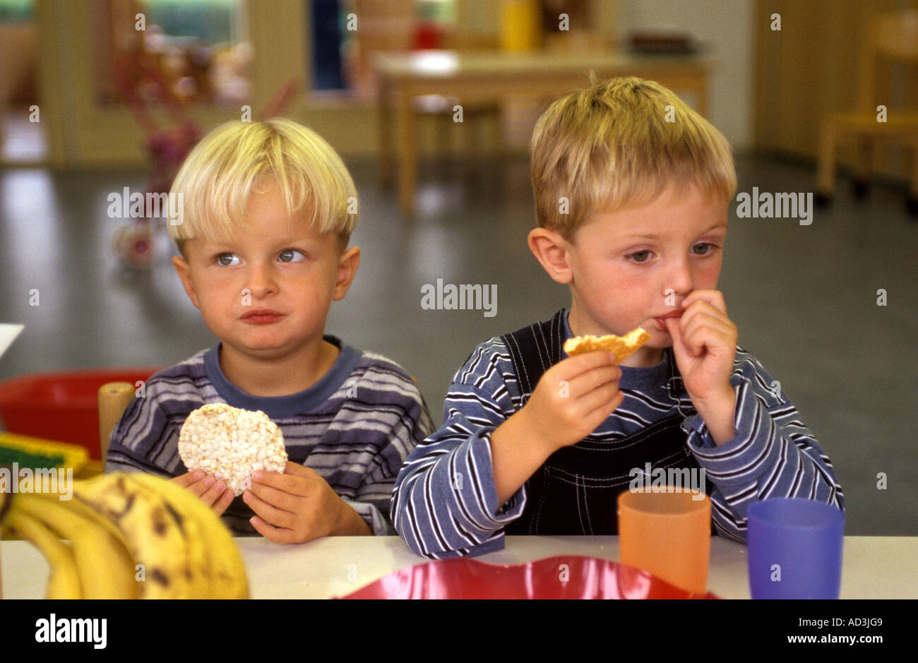 Zwei jungen essen Reis-Cracker in einer Kindertagesstätte Stockfoto